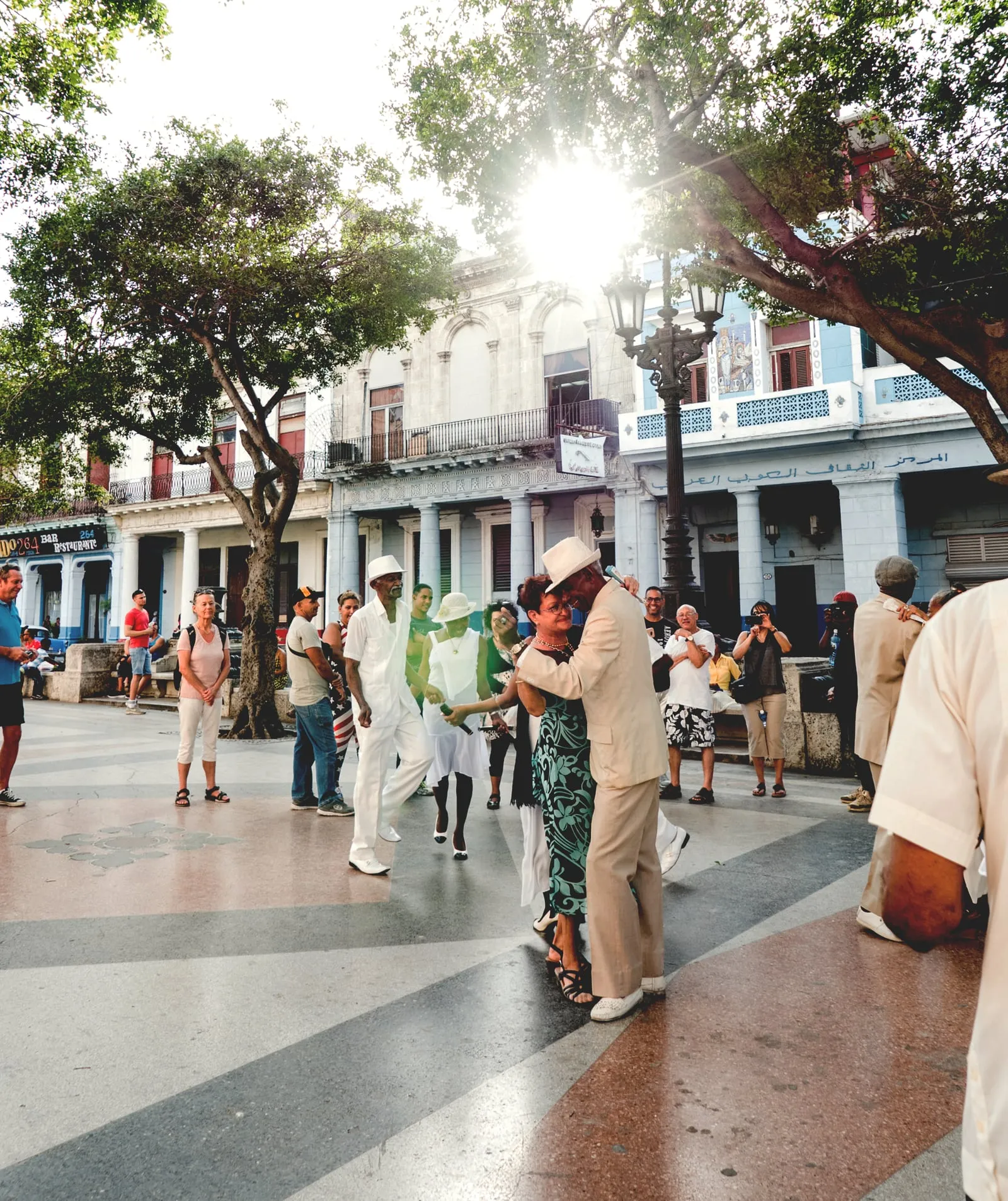 Un couple danse le son sur une place de La Havane, chapeaux et guayaberas