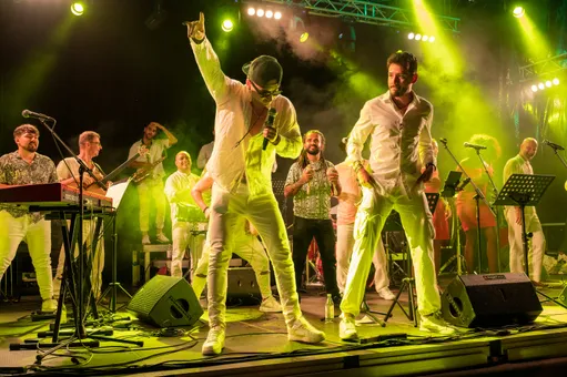 Les chanteurs de Nolosé lancent la danse en front de scène à JazzAscona, l’orchestre en blanc derrière eux