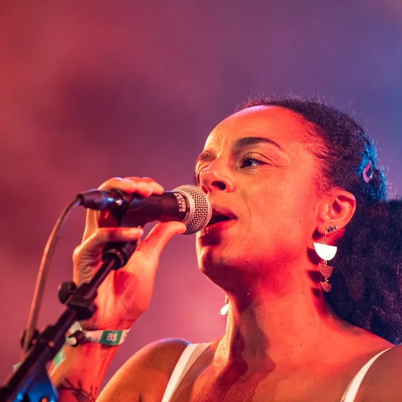 Chanteuse de Nolosé au micro, lumière de festival